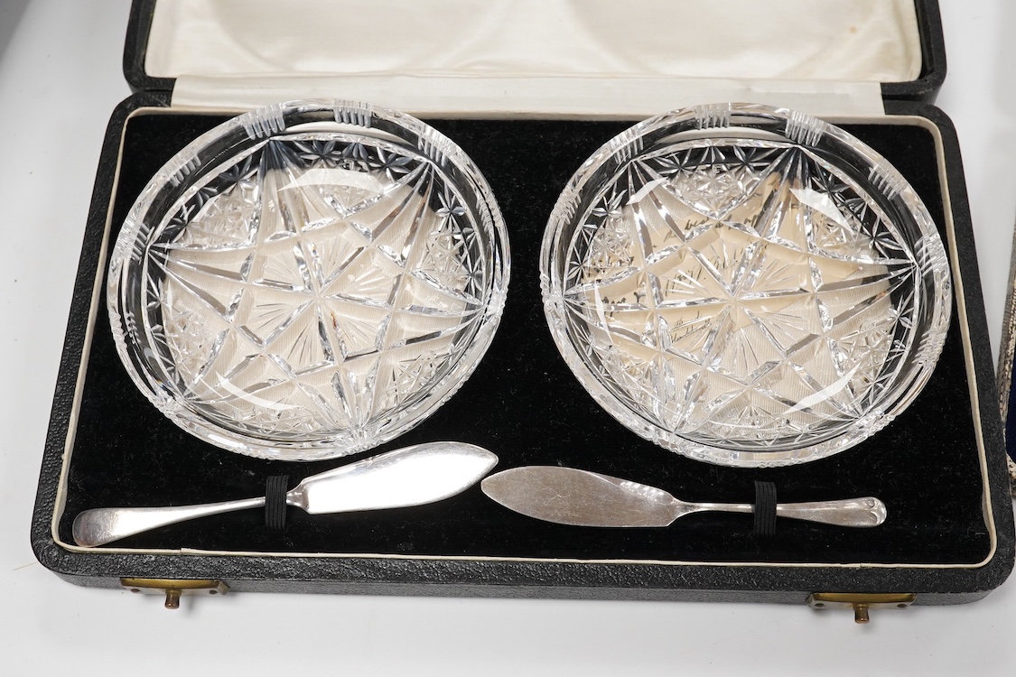 A collection of assorted silver to include five napkin rings including two pairs, a cased pair of glass butter dishes with silver butter knives, five golf related teaspoons, a cased set of six sterling cocktail sticks wi